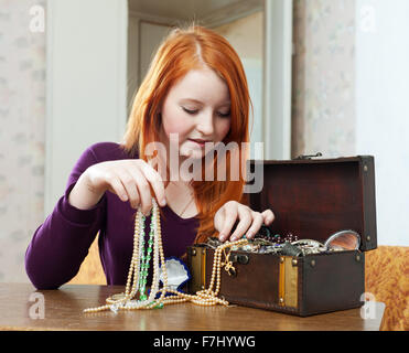 Teen ragazza sceglie i gioielli in Treasure Chest Foto Stock