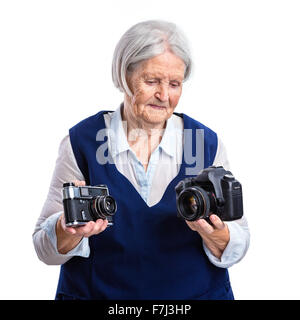 Senior donna scegliendo tra la vecchia telecamera analogica e digitale moderna uno Foto Stock