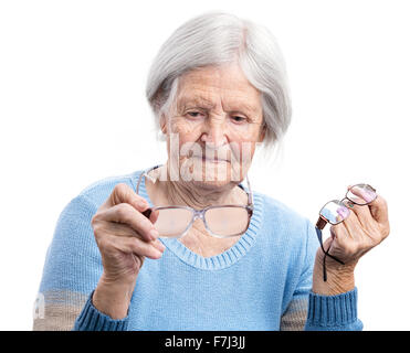 Senior donna holdig due paia di occhiali e scegliendo uno adatto Foto Stock