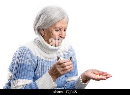 Donna anziana tenendo le sue medicine su bianco Foto Stock