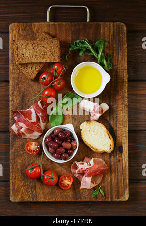 Il cibo italiano still life - olive, pomodori e basilico, il prosciutto crudo Foto Stock