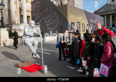 Un esecutore di strada verniciato argento dando l'illusione che egli è la levitazione di fronte alla National Gallery di Londra, UK Foto Stock