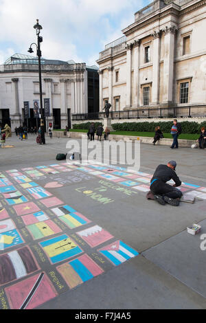 Street performer disegno le bandiere del mondo in Chalk sul marciapiede davanti alla National Gallery di Londra Regno Unito Foto Stock