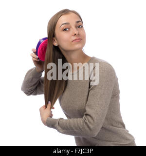 20 anno vecchia ragazza viene pettinato in studio, isolare il bianco. Foto Stock