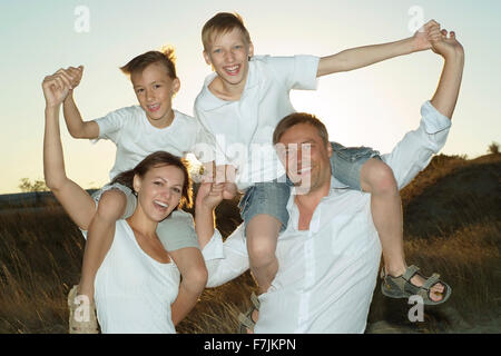 La famiglia felice nel campo di grano Foto Stock