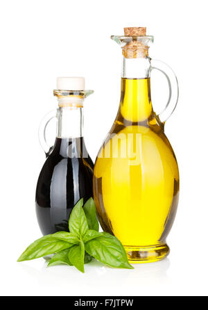 Olio di oliva e aceto bottiglie con basilico. Isolato su sfondo bianco Foto Stock
