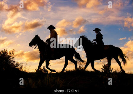 Padre e figlia a cavallo al tramonto, Colorado Foto Stock