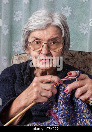 Ritratto di un vecchio rugoso Maglieria donna nella sua casa. Foto Stock