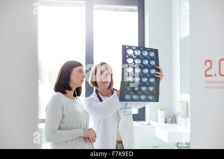 Grave il medico e il paziente rivedendo i raggi x in sala esame Foto Stock