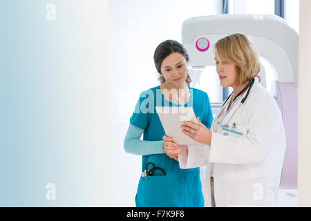 Medico e infermiere con tavoletta digitale nella sala esame Foto Stock