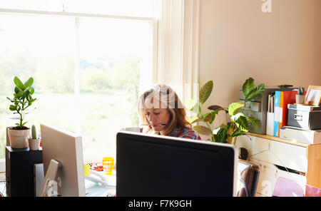 Focalizzato donna che lavorano in ufficio in casa Foto Stock