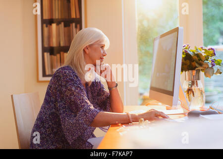 Senior donna che lavorano al computer in ufficio in casa Foto Stock