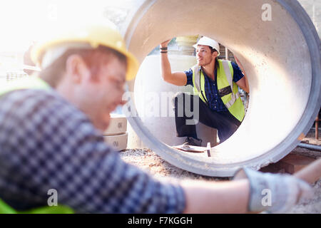 Operaio edile esaminando un tubo di calcestruzzo Foto Stock