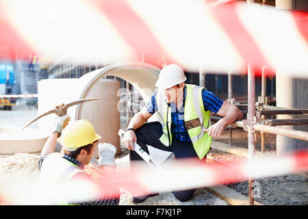 Lavoratori edili parlando al sito in costruzione Foto Stock