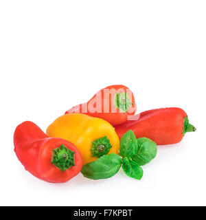 Peperoni colorati con foglie di basilico Foto Stock