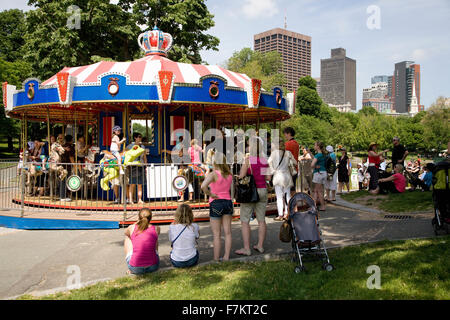 I genitori guardare i bambini cavalcare il Frog Pond Merry-Go-Round in Boston Common Park del Memorial Day, 2011, Boston, MA Foto Stock