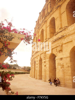 Un gruppo di uomini tunisini sedersi fuori dell'antico anfiteatro romano di El Jem. Foto Stock