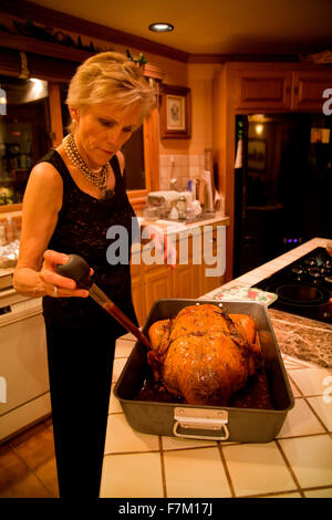 Melody Taft prepara il tacchino del Ringraziamento usando un baster, Ojai, CA Foto Stock