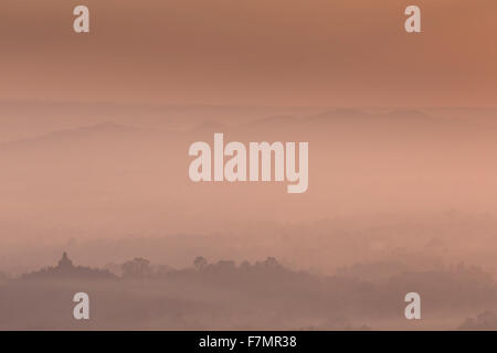 Colorato tramonto sul vulcano Merapi e tempio di Borobudur in misty giungla foresta, Indoneisa Foto Stock