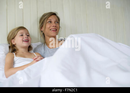 Madre e figlia di guardare la tv insieme a letto Foto Stock