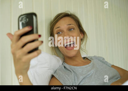 Donna sorridente, tenendo selfie Foto Stock