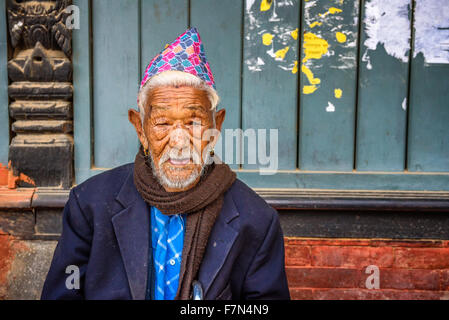 Anziani uomo seduto in strada di Kathmandu Foto Stock