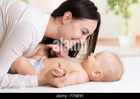 Felice madre guardando il bambino in camera da letto Foto Stock