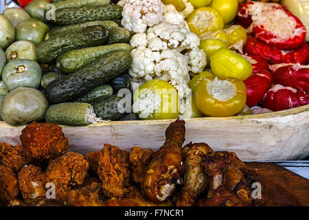 Rumeno tradizionale sottaceti, polpettone di pollo e carne fritta, poste in vasi di legno. Foto Stock