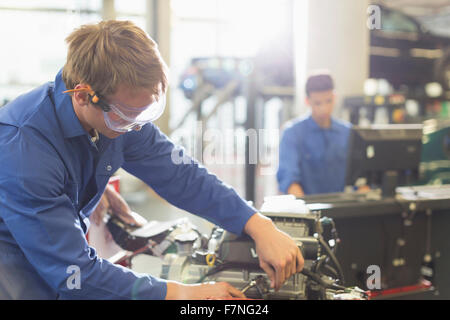 Lavoro meccanico sul motore in negozio di riparazioni auto Foto Stock
