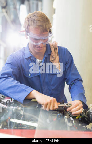 Lavoro meccanico sul motore in negozio di riparazioni auto Foto Stock