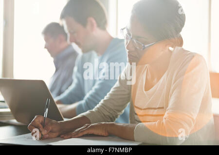 Imprenditrice prendendo appunti in riunione Foto Stock