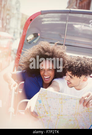 Entusiasta giovane con mappa su autobus a due piani Foto Stock