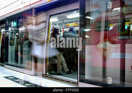 Vista orizzontale di un last minute commuter sbatti per arrivare sulla MTR come le porte sono di chiusura. Foto Stock