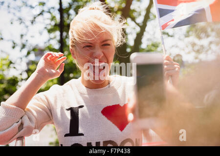 Donna entusiasta sventola bandiera britannica fotografato Foto Stock