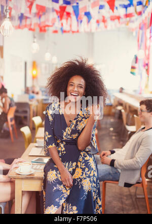 Ritratto di donna entusiasta con afro in cafe Foto Stock