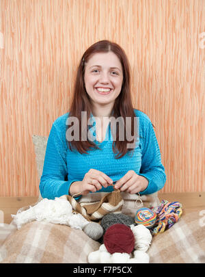 Giovane donna una tessitura a maglia-pin a casa Foto Stock