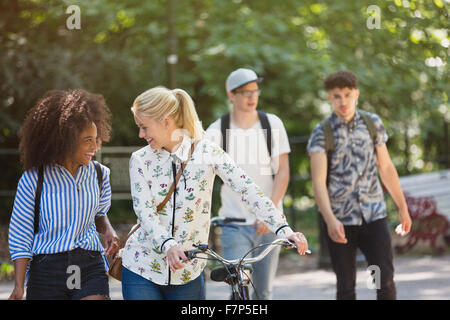 Amici camminando con la bicicletta in posizione di parcheggio Foto Stock