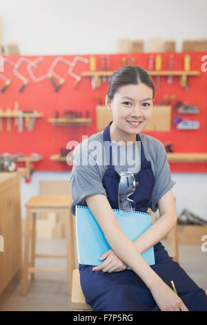 Ritratto femminile fiducioso falegname in officina Foto Stock