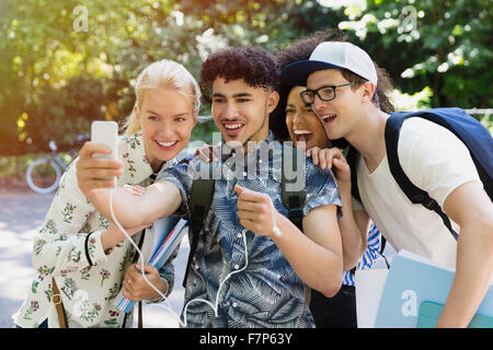 Amici prendendo selfie con la fotocamera del telefono in posizione di parcheggio Foto Stock
