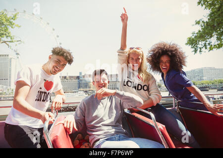 Ritratto di amici entusiasti riding double-decker bus, London, Regno Unito Foto Stock