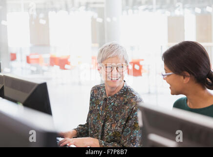 Donna sorridente parlando a computer di educazione degli adulti classroom Foto Stock