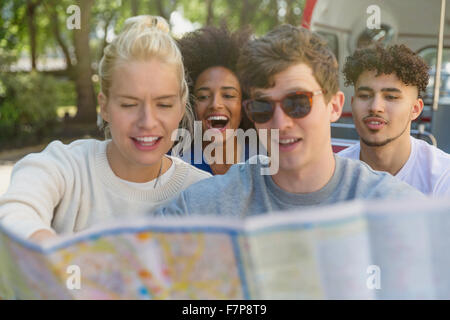 Amici guardando la mappa su autobus a due piani Foto Stock