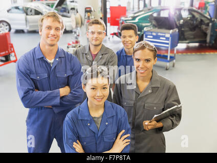 Ritratto fiducioso meccanica nel negozio di riparazioni auto Foto Stock