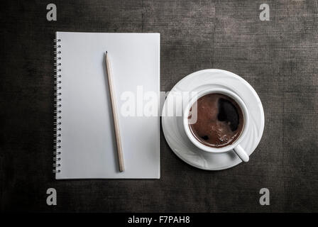 Notebook, penna e il caffè sul tavolo. Da sopra Foto Stock