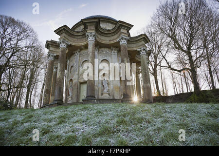 Luce del sole di mattina proveniente attraverso le colonne del Tempio di Apollo a Stourhead, Wiltshire, su una gelida giornata di gennaio. Foto Stock