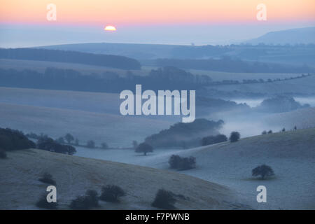 Una vista nebbiosa attraverso il Sussex Downs all'alba, da Ditchling Beacon, East Sussex. Foto Stock