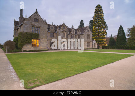 La casa a Wakehurst Place, West Sussex, al crepuscolo, con un grande abete coperto di luci di Natale. Foto Stock