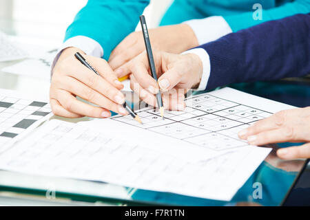 Le mani con la matita risolvere sudoku come formazione di memoria Foto Stock