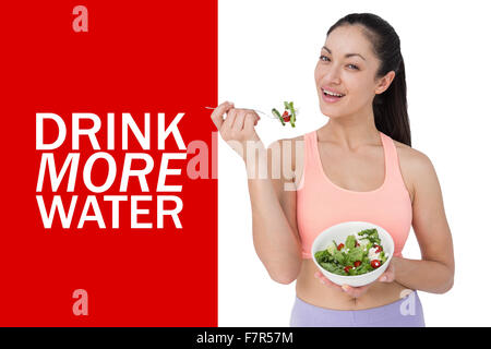 Immagine composita di sorridere brunette mangiare insalata Foto Stock