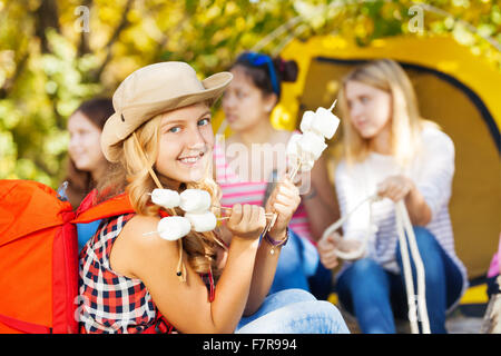 Ragazza indossando hat detiene bastoni con marshmallow Foto Stock
